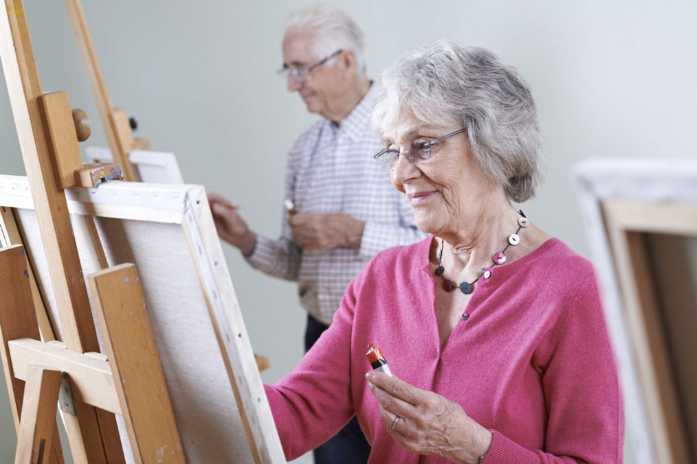 grupo de adultos en un taller de arte pintando sobre atriles
