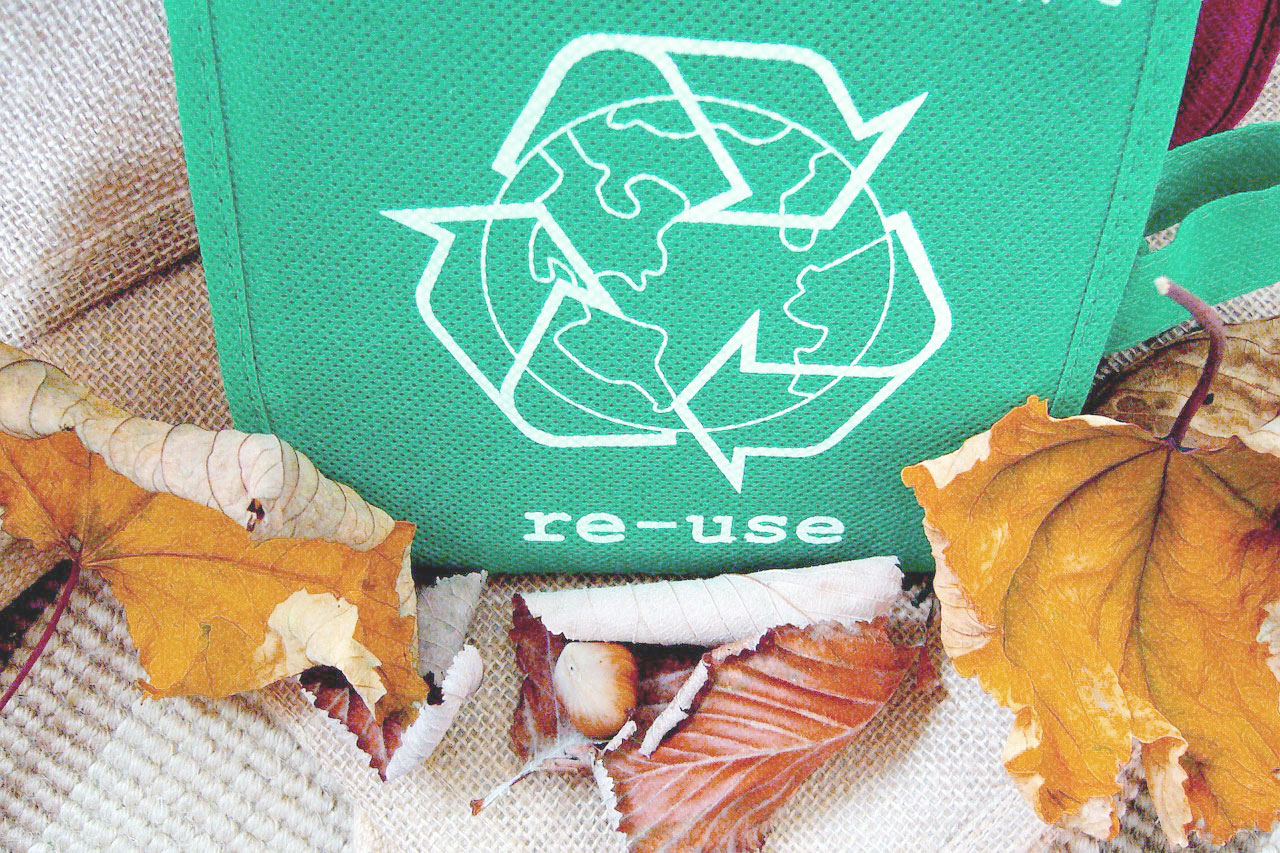 icono de re usar en una bolsa re utilizable y hojas otoñales