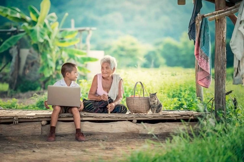 mujer anciana y niño con notebook, paisaje muy rústico