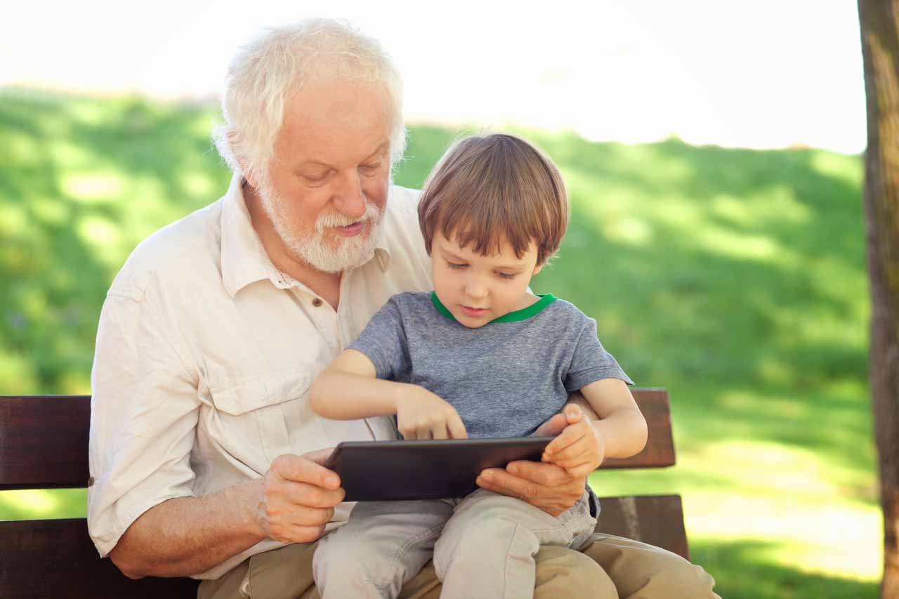 abuelo jugando con su nieto utilizando una tablet
