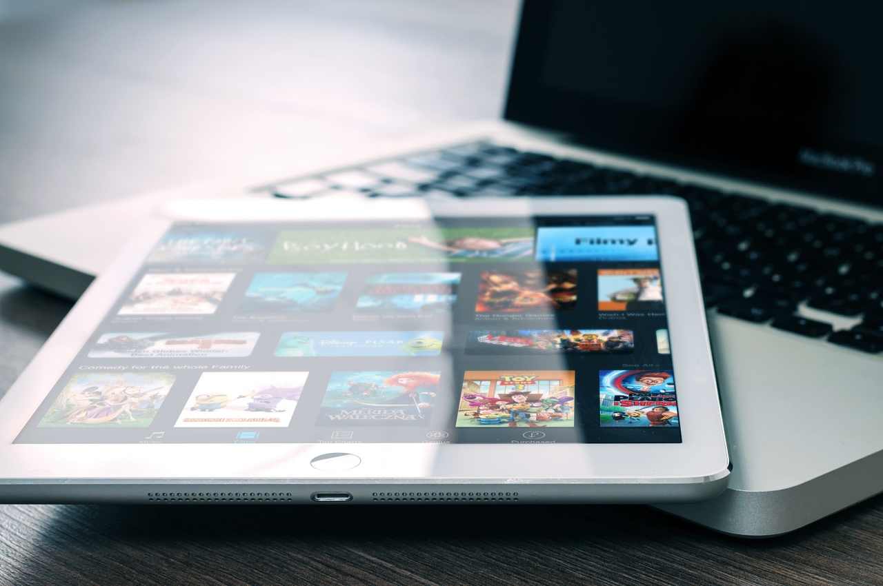 Tablet apoyada en una notebook con la pantalla de Netflix
