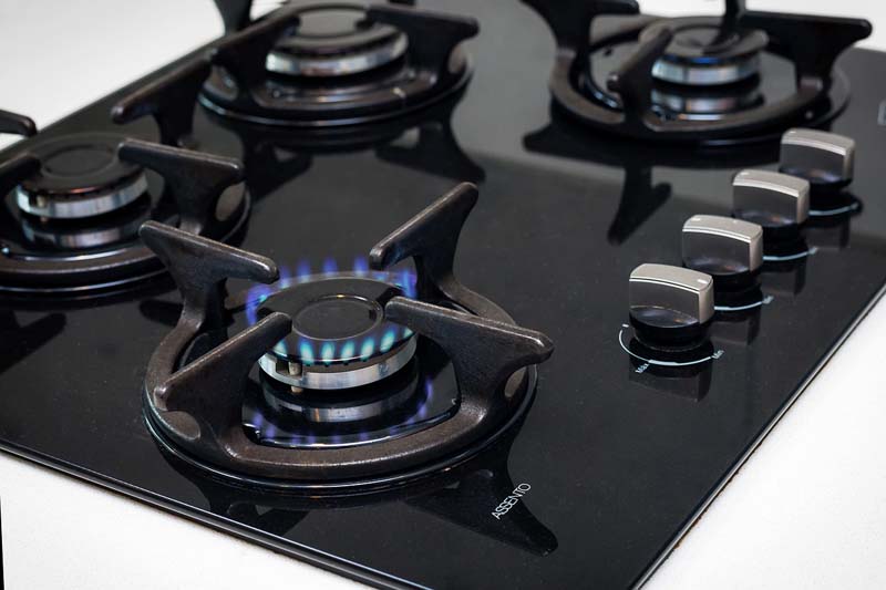 cocina prendida con llama a gas sugiriendo ahorrar dinero en su consumo