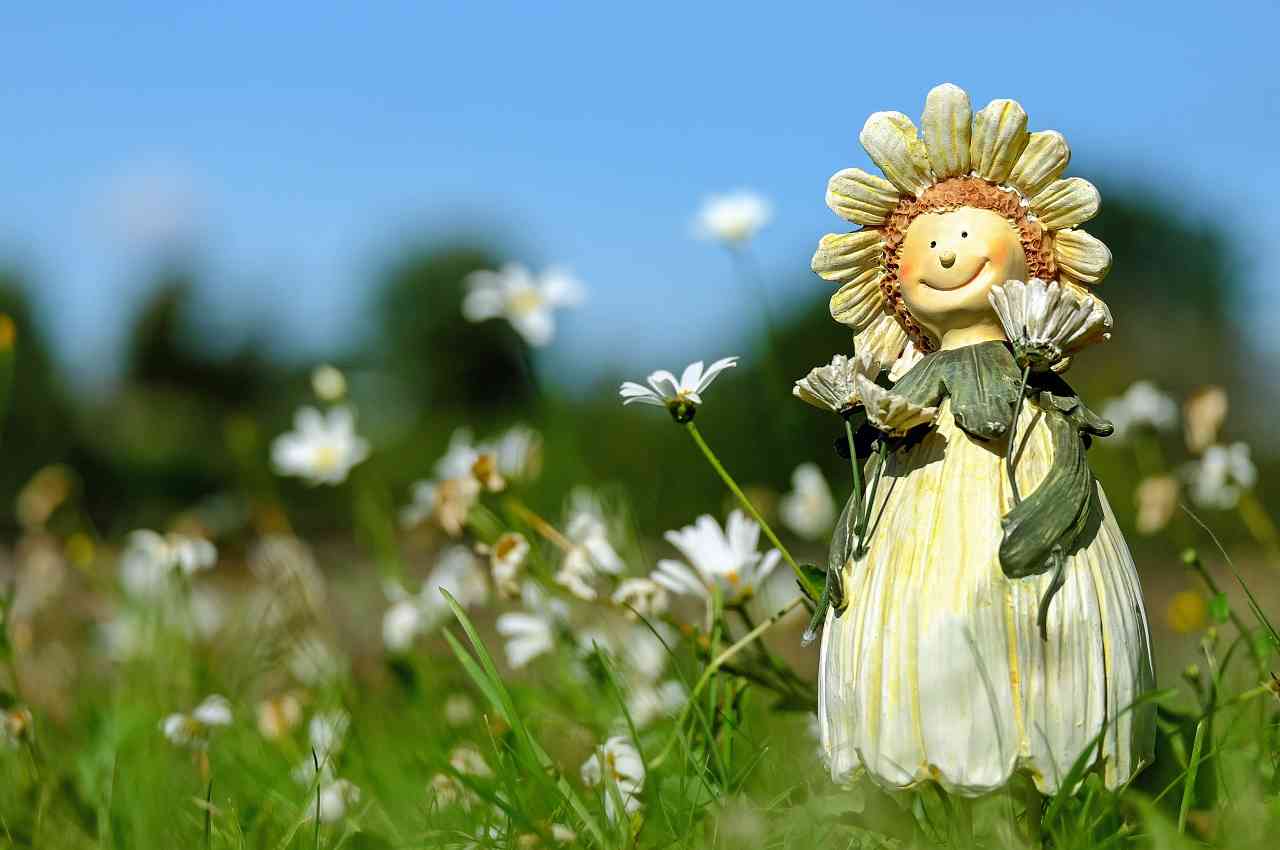 imágen de muñeca con forma de flor sonriendo en medio del campo muy motivada