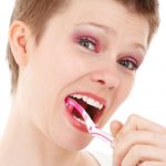 señora que cepilla sus dientes de forma alegre