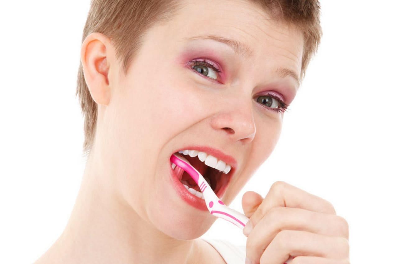 señora que cepilla sus dientes de forma alegre