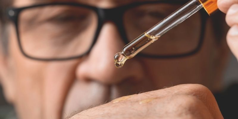 primer plano de un gotero vertiendo unas gotas de retinol