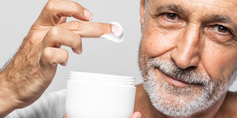 persona mayor aplicando crema hidratante en rostro