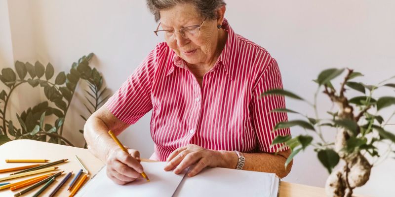 mujer mayor dibujando con lápices de colores